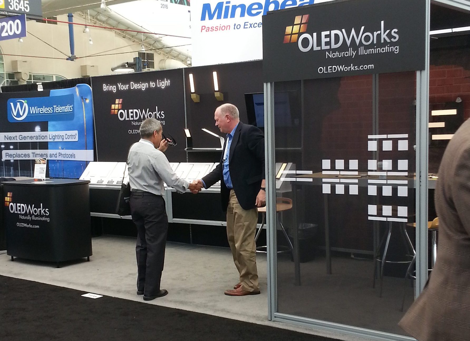Jeff Jackson welcomes a visitor to the OLEDWorks booth at Lightfair 2016