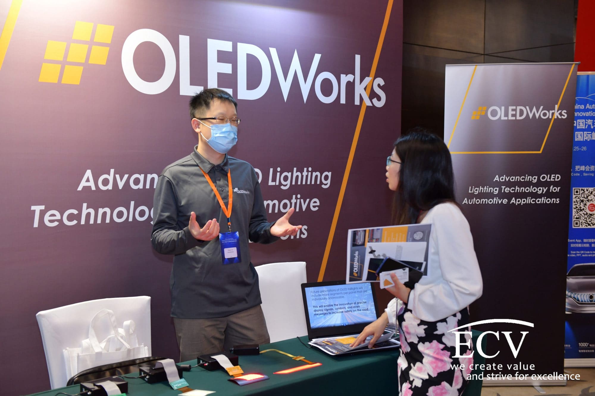 Attendees visit the OLEDWorks booth
